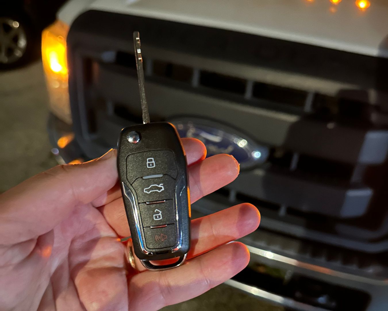 Replacement remote flip key held in front of a 2012 Ford F-350 in Sarasota