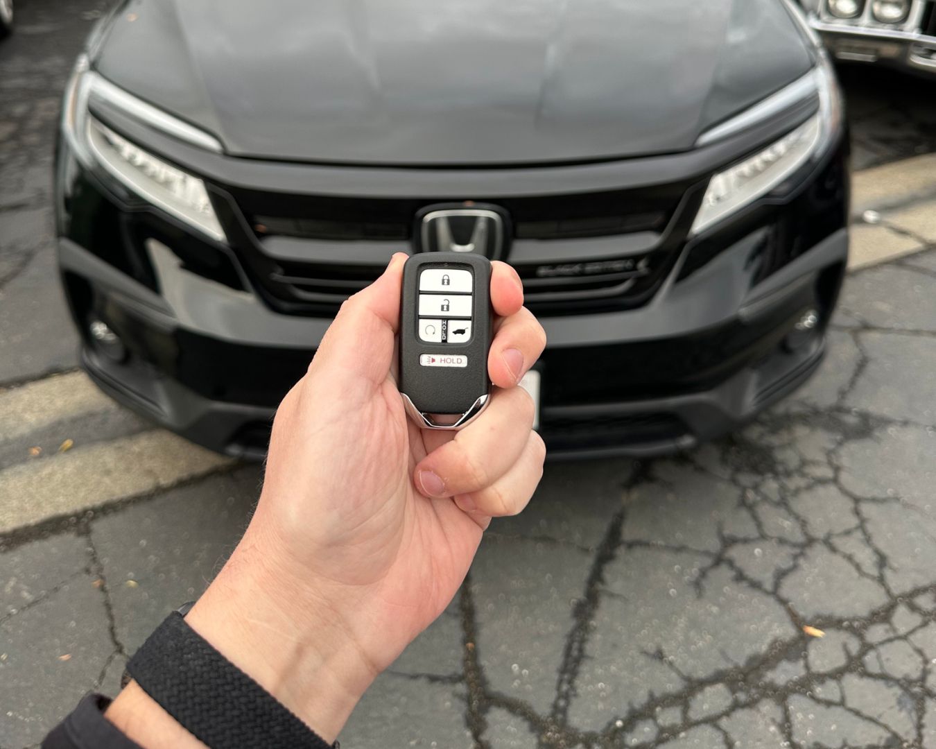 Honda key fob held in front of the vehicle during a 2018 Honda Pilot additional-key job.